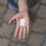 Main ouverte avec 2 pièces d'argent dans la paume.